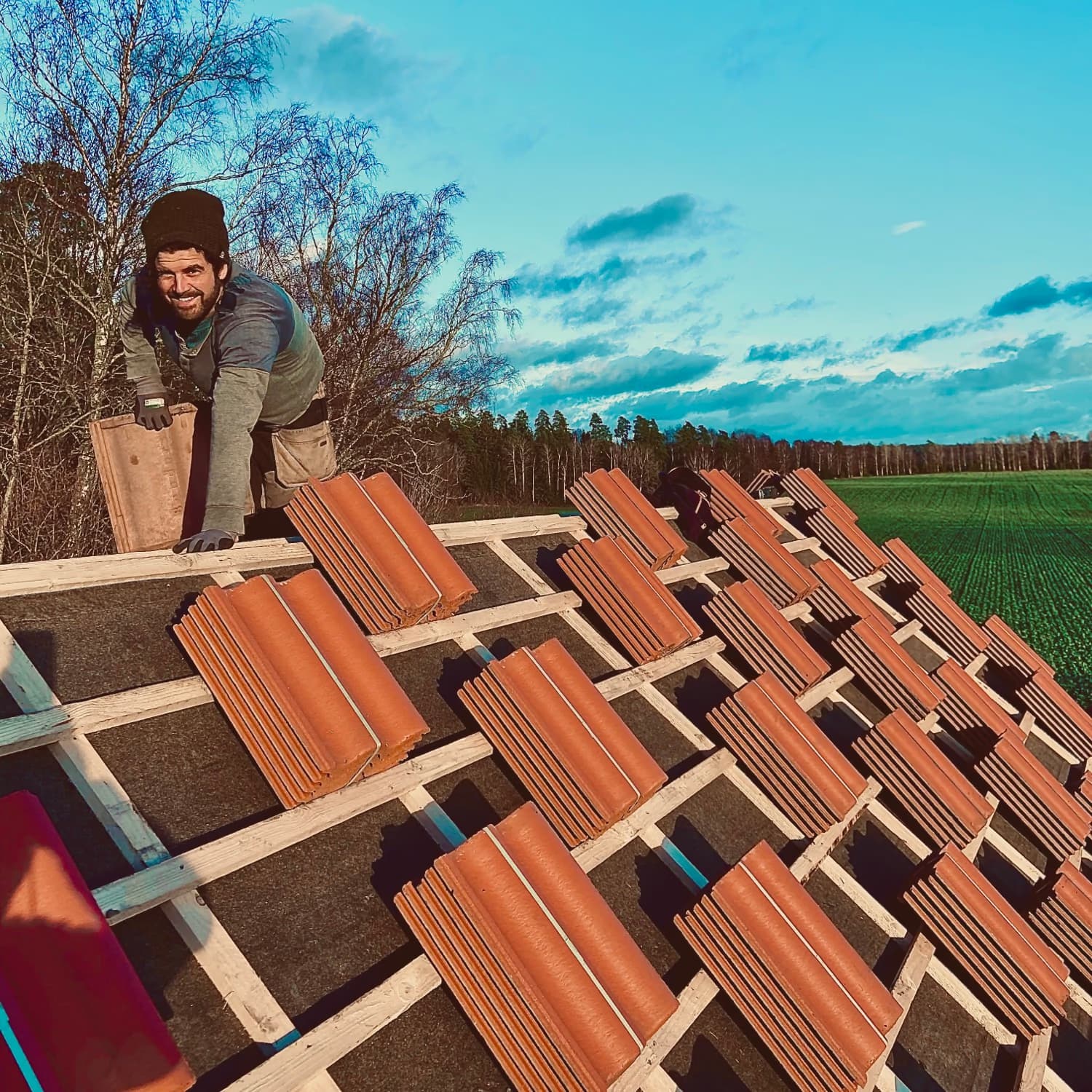 Hantverkare lägger tegelpannor på ett tak